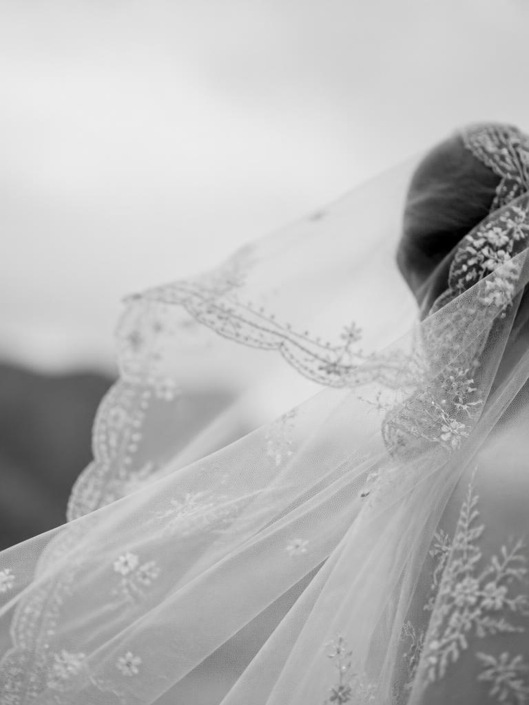 Black and white close up of a couture wedding veil blowing in the wind